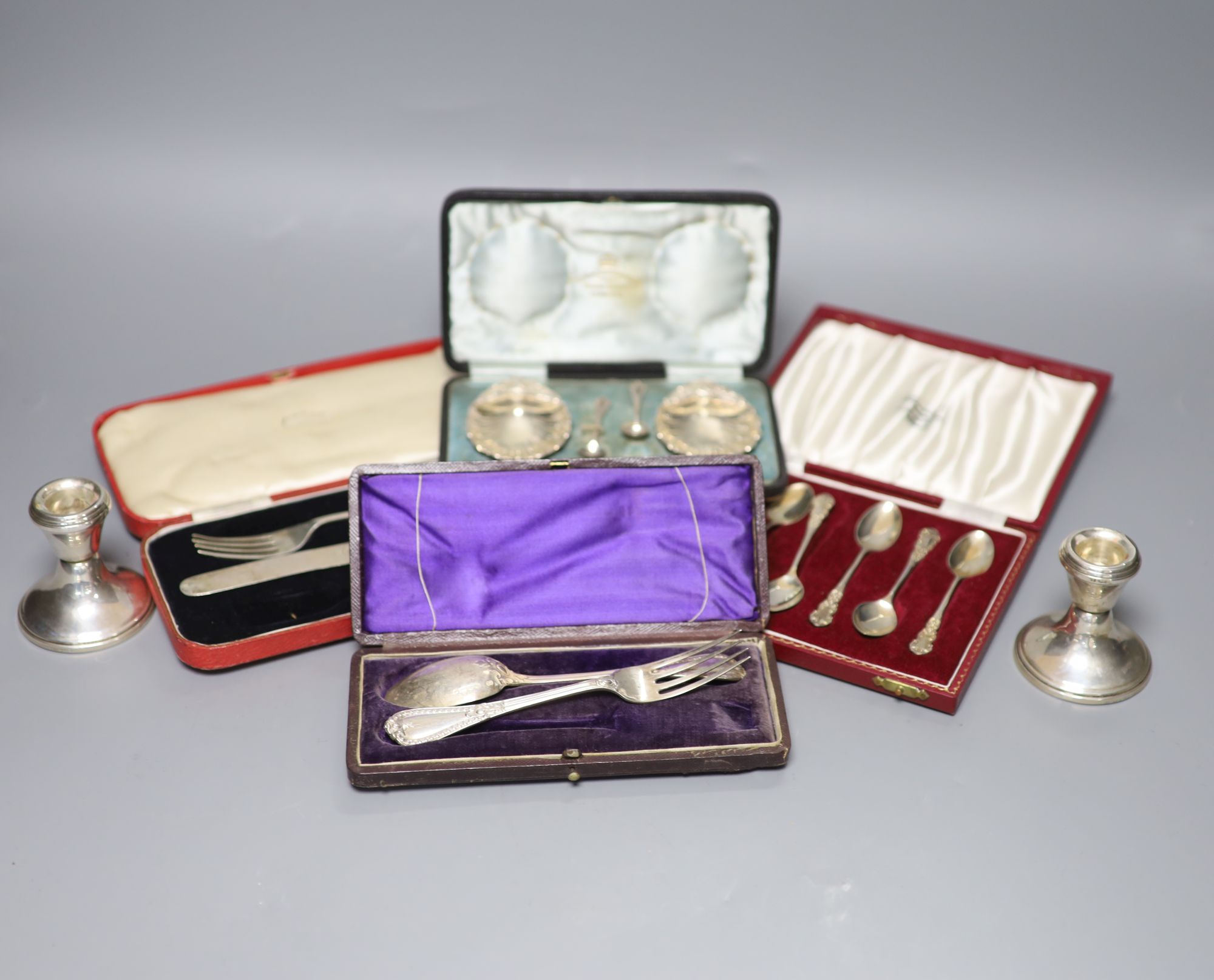 A pair of silver dwarf candlesticks and various cased silver items,